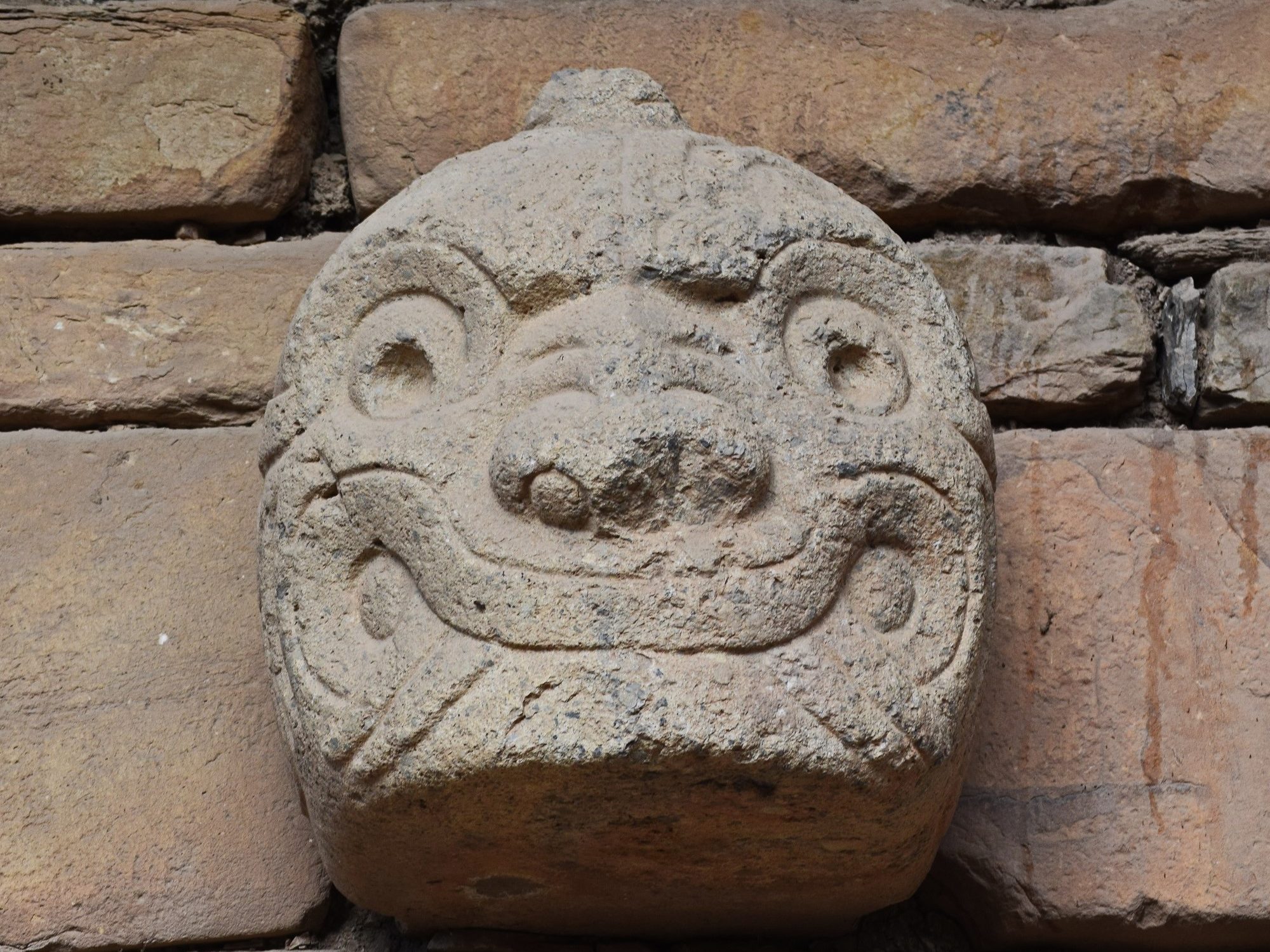 An image of a tenon head in the facade of the temple structure at Chavin