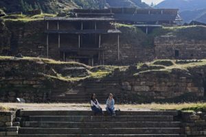 Image of the archaeological site of Chavin de Huantar with research assistants Antonella Rivera Tames and Carly Rose Lacoste seated on steps